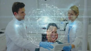 Diş hekimi ve asistanı diş kliniğinde tedavi planını gösteren tableti kullanıyor. Tıbbi, teknoloji, fütüristik, sağlık, dijital, işbirliği, yenilik