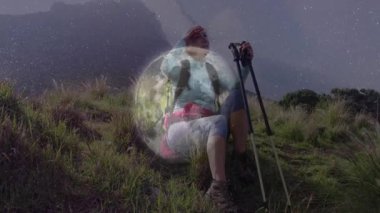 Yürüyüşçü mola vererek yamaca tırmanıyor ve seyahat pazarlaması için puslu sırtı gözden kaçırıyor. Macera, keşif, dayanıklılık, doğa, açık hava, vahşi yaşam, dayanıklılık.