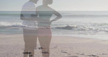 Sahile gelen çift kollarını gezmek için ufku paylaşıyorlar ve hareketli dalgalar yükseliyor. Romantizm, sahil, sükunet, bağlantı, dinginlik, rahatlık, manzara