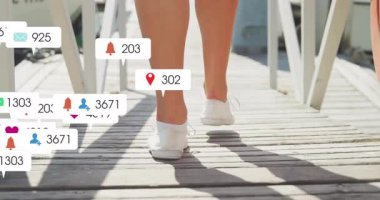 Ahşap iskele tebligat baloncukları üzerinde yürüyen kadın sosyal medya artışını gösteren ayakkabılarla çoğalıyor. Açık hava, eğlence, teknoloji, bağlantı, şehir, yaşam tarzı, canlı