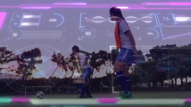 Neon-vetli oyuncu animasyon kaplama altında top sürmeye başlıyor, defans oyuncusu futbol taliminde kayıyor. Atletik, takım çalışması, strateji, hareket, rekabet, spor, açık hava