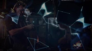 Metal işçisi kızgın metali ocağa yedirip örs üreten holografik küreye vuruyor. Metalcilik, yenilik, dijital alarm, endüstriyel, fütüristik, teknoloji, işçilik