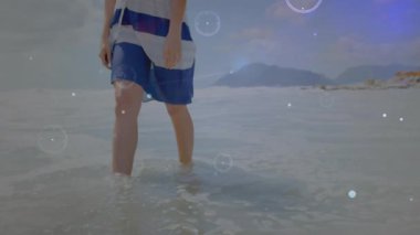 Sörf yapmaya başlayan bir kadın çizgiler ve daireler çizerek yürür. Teknoloji gösterisinde parlayan çizgiler oluşturur. Sahil, sahil, dijital, fütüristik, huzur, hareket, çevre