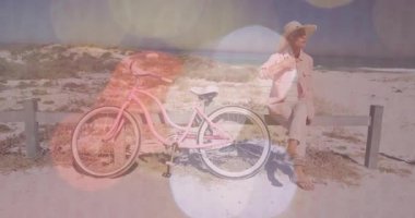 Son sınıf öğrencisi kadın, bisiklet raylarında kahve yudumluyor seyahat ediyor şapka kaldırıyor mercek ışığıyla ufuk çizgisini tarıyor. Sahil, tatil, rahatlama, açık hava, huzur, tatil, doğa.