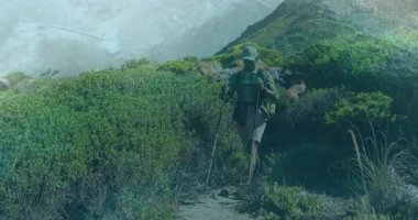 Yürüyüşçülerin çalılıklardan çıktığı, yürüyüş direklerini kavradığı, iz sürme görüntüsünü izlediği bir yolculuk. Macera, keşif, açık hava, engebeli, vahşi doğa, aktivite, doğa.