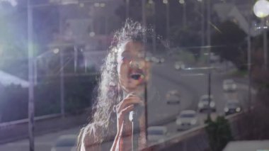 Mikrofon tutan ve müzik performansında yüksek notalara ulaşan kadın şarkıcı. Müzik, vokalizasyon, performans, sahne, gece hayatı, şehir, atmosfer