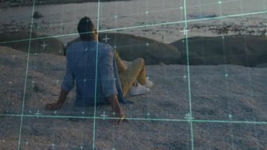 Teknik şebeke çakıllı sahil tarama sahnesini tararken bir adam ufka bakıyor. Gelecekçi, düşünceli, atmosferik, dinginlik, minimalist, dijital, manzara