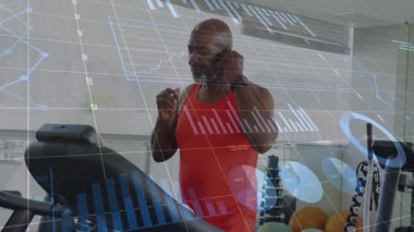 Fitness adamı kulaklıkları takıyor ve spor salonunda koşu bandına başlıyor, yürüyor, koşuyor ve istatistikleri izliyor. Sporcu, sağlık, modern, aktif, eğitim, sağlık, kardiyo