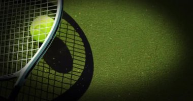 Tenis raketi ve topun yeşil yüzey renklendirme takımlarının üzerinde durduğunu gösteren güneş ışığı merceği yakınlaşıyor. Spor, atletik, rekabetçi, enerjik, açık hava, minimalist, enerji