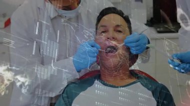 Diş sandalyesine yaslanan hasta dişçi ve asistanı, dişlerini veri örtüsüyle inceliyor. Diş sağlığı, muayene, hijyen, sağlık hizmetleri, klinik, tıbbi, mesleki