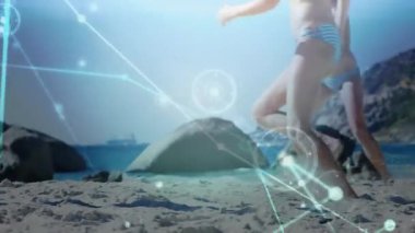 Gelen topa tepki veren iki voleybol oyuncusu teknolojik kaplamayla bloğa sıçrıyor. Atletizm, spor, yaz, eğlence, dinamik, enerji, açık hava