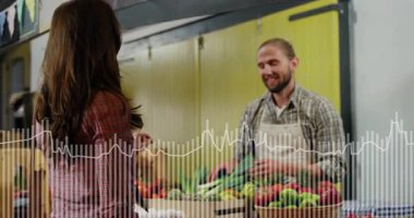 Kadın markete geliyor, satıcıları selamlıyor, ahşap kasalardan yeşillikler seçiyor ve ödeme alıyor. Perakende, ticaret, tazelik, sürdürülebilirlik, bokeh, rustik, toplum