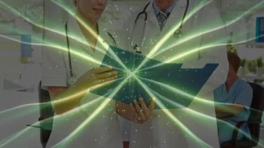 Tıp doktorları mavi klasörü açıp dosyayı inceliyor, yeşil ışık yanıp sönüyor. Sağlık, işbirliği, profesyonellik, teşhis, teknoloji, tıbbi ekip, klinik