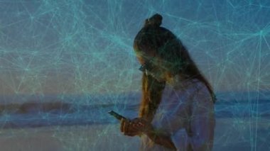 Yetişkin bir kadın gün batımında beklerken ağ telefon ve mesajlarda kayboluyor. Yalnızlık, bağlantı, alacakaranlık, ufuk, dijital, meditasyon, dinginlik