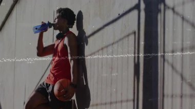 Turuncu basketbolu kapan, su şişesini yudumlayan ve sahada anket yapan erkek sporcuları eğittikten sonra. Sporcu, antrenman, spor, spor, kararlılık, dayanıklılık