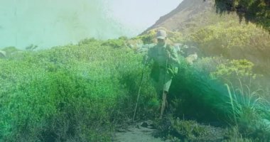 Yürüyüşçü dağ yoluna adım atıyor, yürüyüş direkleri dikiyor ve zindelik için tepeye doğru tırmanıyor. Macera, keşif, açık hava, dayanıklılık, doğa, huzur, manzara