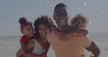 Anne babalar çocukları kumlu sahilde sırtında taşıyorlar. Altın parıltılar sürüş sevincini bastırıyor. Aile, sahil, kutlama, mutluluk, açık hava, coşku, hatıralar.