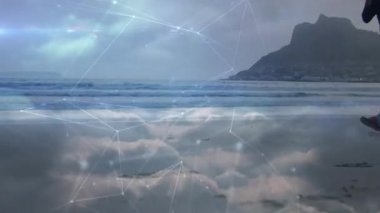 Yarısaydam ağ plaj koşusunda sağlık verilerini haritalarken koşucu ıslak kuma basıyor. Zindelik, sağlık, teknoloji, açık hava, hareket, canlılık, manzara