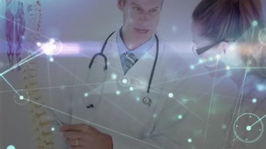 Doktor imleç omurga modelini, titreşim eşleşmesi sırasında aynı hizayı açıklayarak not alıyor. Tıbbi, sağlık, anatomi, eğitim, teknoloji, profesyonel, klinik