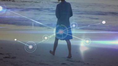 Gün batımında çıplak ayaklı bir kadın ıslak kumda yürüyor ve titreşimli teknoloji ağı veri büyümesini engelliyor. İzleme, bağlantı, dinginlik, yenilik, fütürizm, minimalizm, sükunet