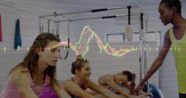 Eğitmen, reformcuları zorlayan, duruşu animasyon ölçümleri ile hizalayan katılımcıları işaret ediyor. Spor, grup çalışması, sağlık, etkinlik kıyafeti, modern, sağlık, egzersiz