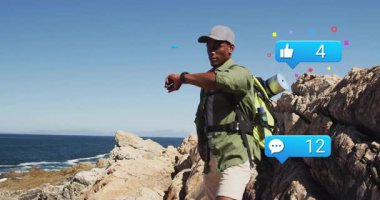 Erkek yürüyüşçüler kayalık sahilde akıllı adımlar atıyorlar, çatışmaları izlemek için sosyal medya simgeleri oluşturuyorlar. Macera, keşif, teknoloji, açık hava, esneklik, bağlantı, ufuk çizgisi