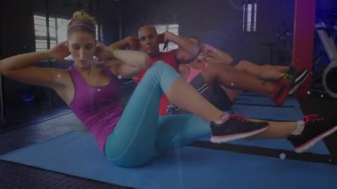 Dinlendikten sonra beş sporcu paspaslar üzerinde bisiklet mekiği çekerek lens fişeği ekliyor. Fitness, power, team work, active, motivasyon, atletik, wellness