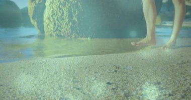Bir adam kayıyor ve sağlık tavsiyesi almak için gelgit havuzuna giriyor ve adımları işaretleyen hareketli ayak izleri var. Deniz kıyısı, rahatlama, açık hava, doğa, sükunet, refah, minimalizm