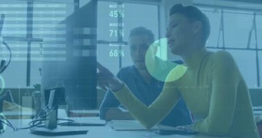 Erkek monitöre bakıyor, kadın işaret ediyor, iş çizelgelerini, yüzdeleri ve harita örtülerini aktifleştiriyor. Analiz, takım çalışması, veri görselleştirme, kurumsal, modern, profesyonel, dijital