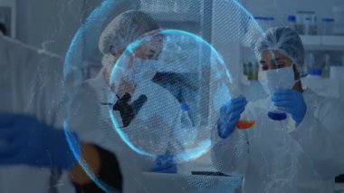 Bilim adamları mikroskop ve matara kullanarak laboratuvarda dönen holografik küreyi çalıştırıyorlar. Teknoloji, işbirliği, yenilik, araştırma, kesinlik, fütüristik, bilim