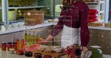 Mutfak sahibi kaseleri düzenler, zeytin yağı şişesini kaldırır, inceler ve animasyon etiketi sunar. Mutfak, gurme, köylü, yaşam tarzı, sunum, yemek pişirme, ev tarzı