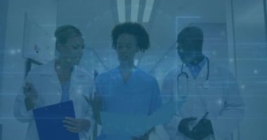 Tıbbi ekip hastane koridorunda yürüyor. Panoya dokunuyor. Hasta çizelgesini tarıyor. Sağlık, takım çalışması, profesyonellik, klinik, danışma, teşhis, işbirliği