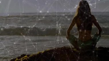 Sağlıklı bir kadın okyanus dalgaları üzerinde dikkatli bir akış başlatıyor ve sakin olmak için titreşimli ağ hatları oluşturuyor. Farkındalık, meditasyon, sükunet, manzara, teknoloji, dinginlik, ufuk