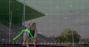 Futbolcu stadyumda top kapmak için çömelmiş, veri haritası takibi ile yukarıdan fırlatma yapıyor. Atletik, performans, hareket, eğitim, uygunluk, veri görselleştirme, yenilik