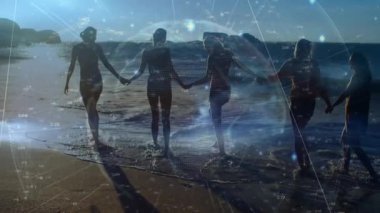 Beş kadın el ele tutuşup dalgaların etkisiyle sörf yaparken teknoloji veri küresi dönüyor. Sosyal, birlik, işbirliği, açık hava, dinginlik, yenilik, modern