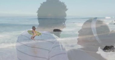 Sörf yapmak için okyanusa giren sarı sörf tahtası tutan sörfçü, gülümseme ve spor paylaşan çifte çapraz geçiş yapıyor. Macera, romantizm, eğlence, uyum, sahil, canlı, bağlantı