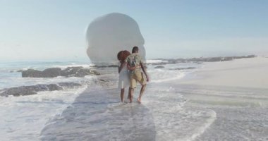 Sörf yapan, el ele tutuşan, aşk yolculuğunu ve şeffaf silueti paylaşan bir çift. Romantik, plaj, kıyı şeridi, samimiyet, macera, sükunet, siluet