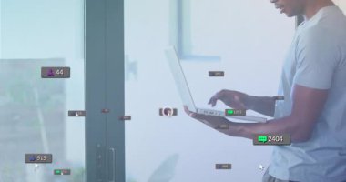 Teknolojik yaşam alanında dizüstü bilgisayarda yazmaya başlayan bir adam yükselen sosyal medya sayaçlarını takip ediyor. Dijital teknoloji, sosyal medya, çevrimiçi bağlantı, ağ, modern iç mekan, sanal iletişim, veri analizleri