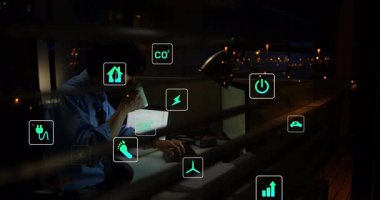 Adam dizüstü bilgisayarda dosya açıp yazarken, animasyon eko simgeleri sürdürülebilirlik verileri gösteriyor. Profesyonel, teknoloji, modern, kentsel, analitik, odaklanmış, veri