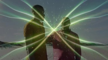 Eğitim danışmanı, plajda öğrencilere el sıkışarak yeşil enerji ışınlarının titreşimine rehberlik ediyor. Ruh, bağlantı, teknoloji, aydınlanma, akıl hocalığı, ilham, ritüel