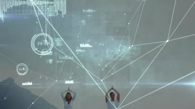 Sahilde yoga yapan dijital titreşimli çift sağlık verilerini izliyor. Dijital, bağlantı, uyum, farkındalık, tahmin, zindelik, sükunet