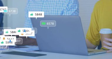 Sosyal medya simgeleri dizüstü bilgisayarın etrafında belirdiğinde, tablette yükselen bağlılığı izleyen iş arkadaşları ortaya çıkıyor. İşbirliği, takım çalışması, analitik, dijital, modern, profesyonel, iletişim