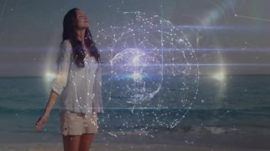 Sahilde duran bir kadın gözlerini kapatıyor ve kollarını açıyor. 3D küreyi çalıştırıyor. Teknolojiyi gösteriyor. Futuristik, dinginlik, farkındalık, holografi, dijital, manzara, yenilik