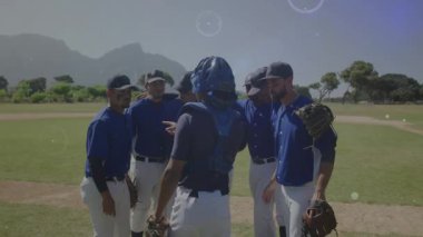 Beyzbol tutucusu sahada toplanıyor ve AR veri ağı oluştururken takım arkadaşlarına koçluk yapıyor. Sporcular, takım çalışması, strateji, dijital, spor giyim, kendine güven, açık hava