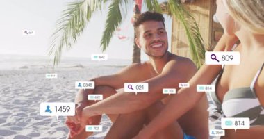 Kadın ve erkek sahilde sohbet ediyor, sosyal medya ikonları yaratıyor, bağlılıklarını gösteriyorlar. Romantik, boş zaman, rahatlama, dijital, tropikal, arkadaşlık, manzara