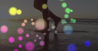 Islak kıyıya adım atan, günbatımı sahilinde yürüyen, seyahat pazarında daireler çizen bir kadın. Deniz kenarı, yansıma, sükunet, atmosfer, siluet, sükunet, hareket