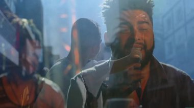 Solist, sokak müziği söylerken mikrofonla öne çıkıp işaret fişeklerine sebep oluyor. Canlı performans, şehir müziği, sokak sahnesi, dinamik, ritmik, canlı, enerjik