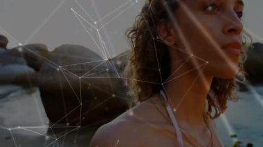 Bir kadın kıyı şeridinde baş izleme güneşine dönüşüyor. Kamera animasyon teknolojisi parlıyor. Dijital, bağlantı, fütüristik, manzara, dinginlik, parlaklık, günbatımı