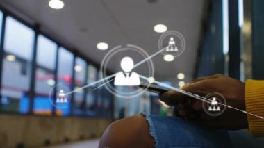 Ulaşım merkezinde akıllı telefonu tutan kadın dijital ağ düğümünü fark ederek genişleyen bir avatar ağı yaratıyor. Bağlantı, teknoloji, arayüz, iletişim, ağ, kentsel, modern