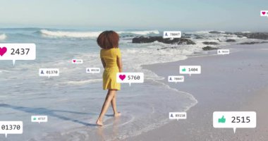 Kumsala giren, sahilde yürüyen sosyal medya sayaçlarını çalıştıran yükselen ve kayaların yanına düşen bir kadın. Sahil, sahil, yaz, dinginlik, dijital, nişan, açık hava